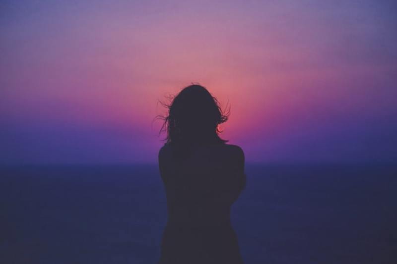 Woman facing sunset in Rhodes, Greece